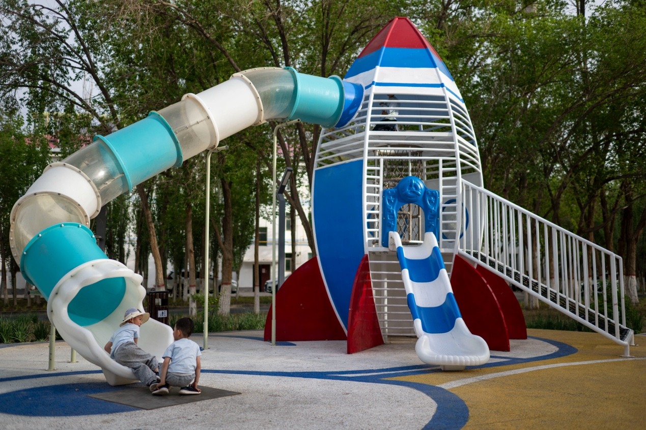 5月23日，酒泉衛星發射中心，在一小區游樂園，孩子們在火箭形狀的滑滑梯上玩耍。人民網記者 翁奇羽攝