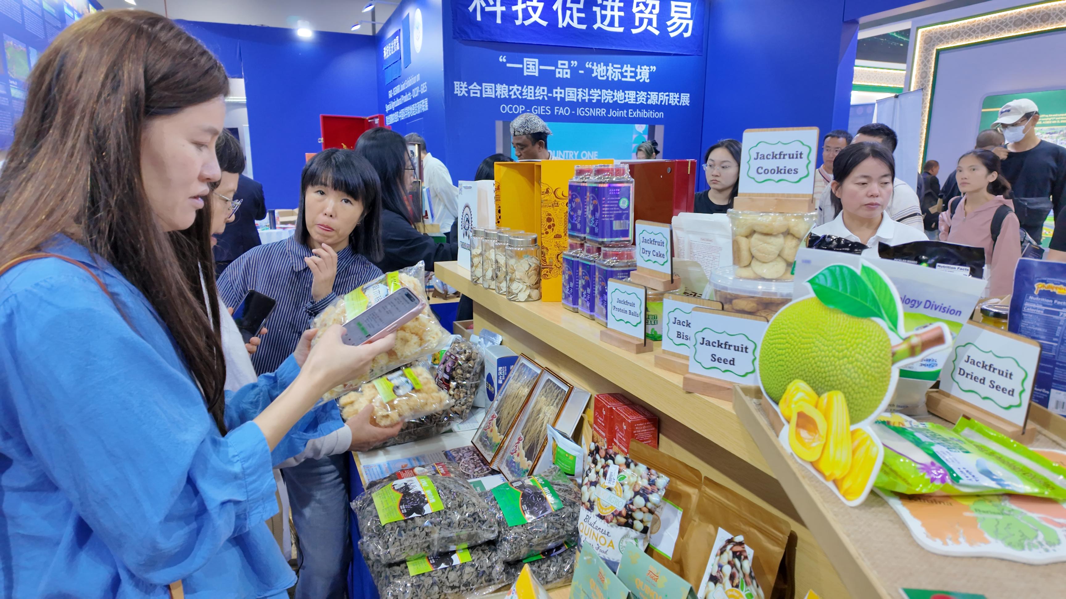 联合国粮农组织-中国科学院地理资源所联展前，观众咨询购买农产品。人民网记者 欧阳易佳摄