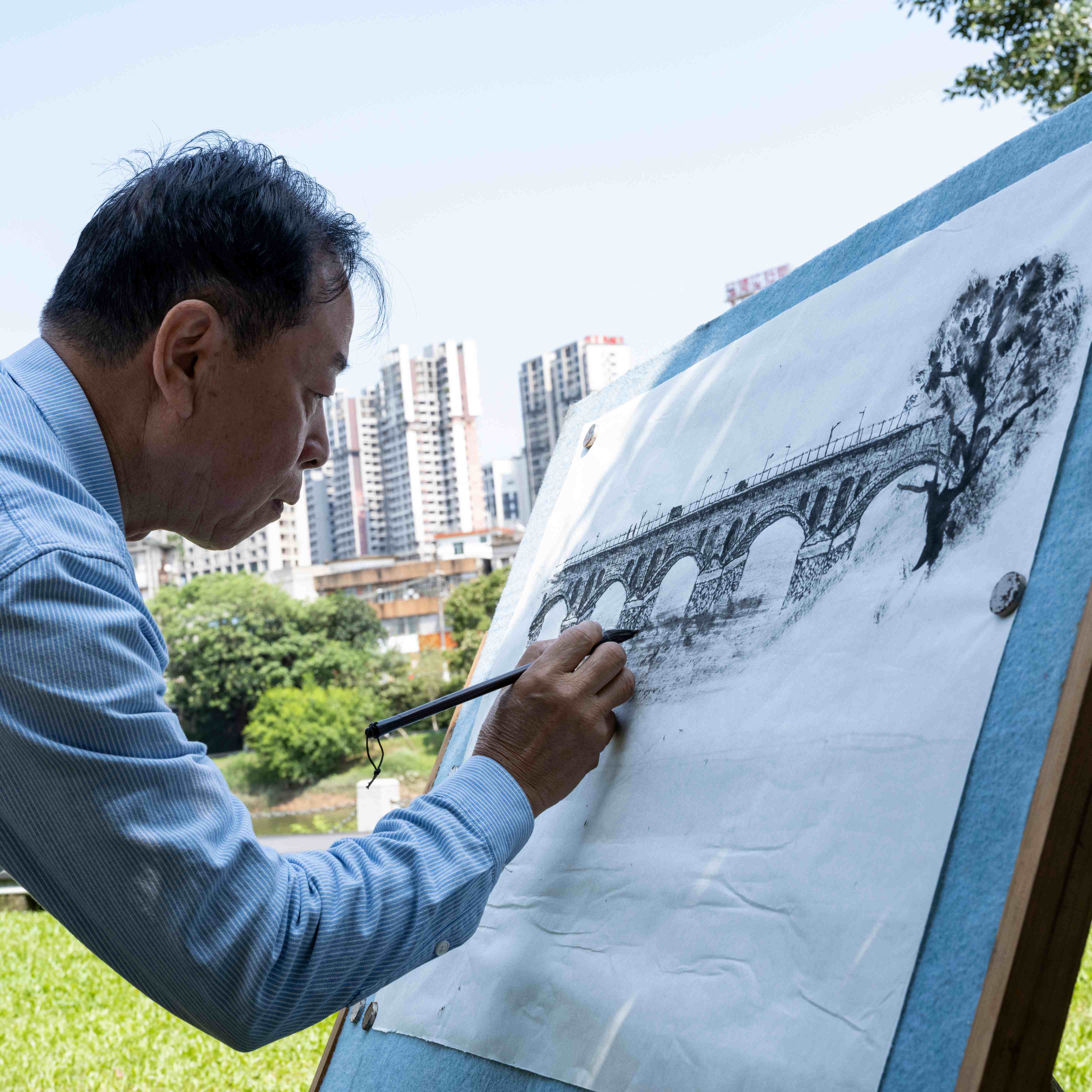 “拍橋人”鏡頭裡的“畫橋人”。 李景琳攝