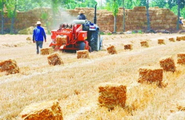 陕西兴平的农机手在麦田里进行小麦秸秆打捆作