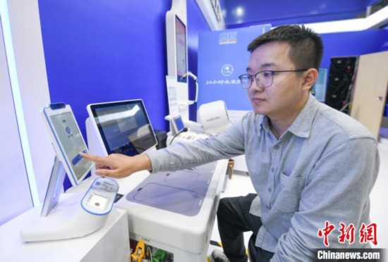 在“中国医保 一生守护”展区，民众体验5G云诊室 王刚 摄