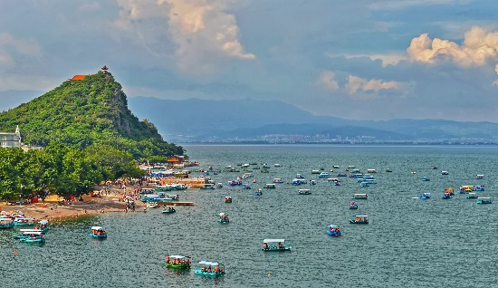 旅客泛舟抚仙湖中，享受山光水色、水天合一的悠然时光。杨杰摄