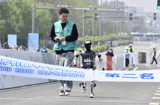 4月19日，在2025北京亦庄半程马拉松暨人形机器人半程马拉松比赛中，小顽童队选手松延动力N2（右）冲向终点。新华社记者李欣 摄