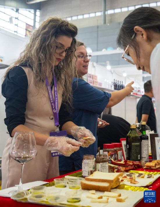 9月19日,在长沙国际会展中心,参展商(左一)在现场制作特色食品。