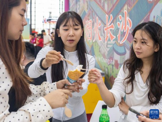 9月19日，在长沙国际会展中心，观众在品尝冰淇淋。