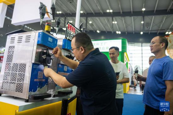 9月19日,在长沙国际会展中心,参展商(左一)在介绍冰淇淋制作设备。