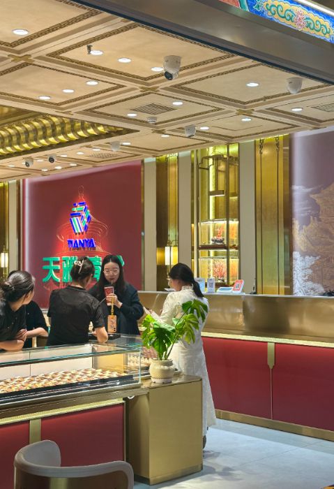 10月28日,在北京市天雅珠宝城某品牌柜台,顾客正在挑选黄金饰品。新华网记者 闫雨昕 摄