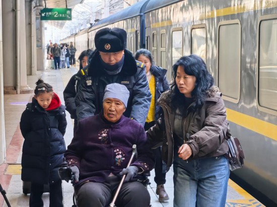朱春生(左三)正在帮助行动不便的旅客出站。新华社记者 叶昊鸣 摄
