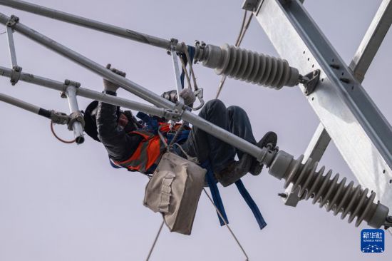 3月13日,工人在哈伊高铁绥化南站施工现场进行接触网作业。