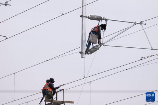 3月13日，工人在哈伊高铁绥化南站施工现场进行接触网作业。