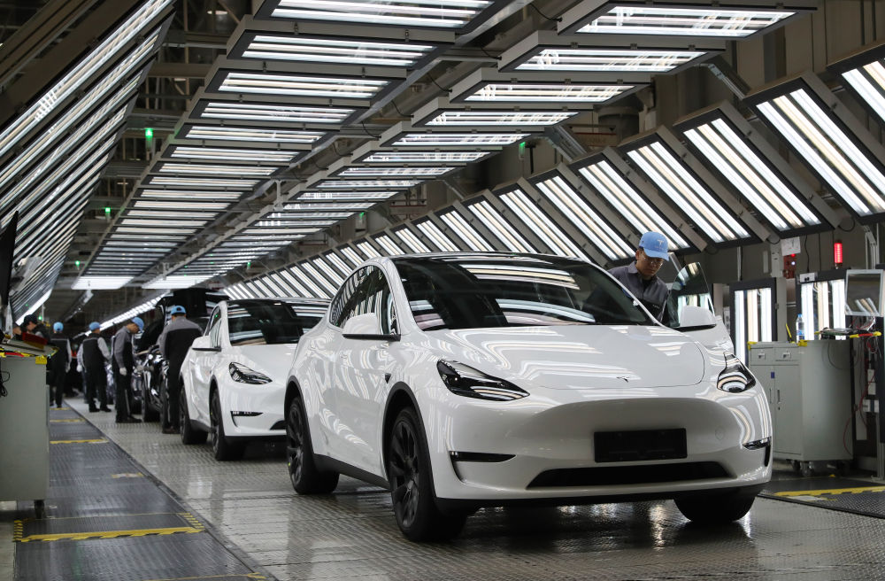 2023年12月22日，在特斯拉上海超级工厂内，工人在对出厂前的车辆进行漆面及门窗检测。新华社记者 方 摄