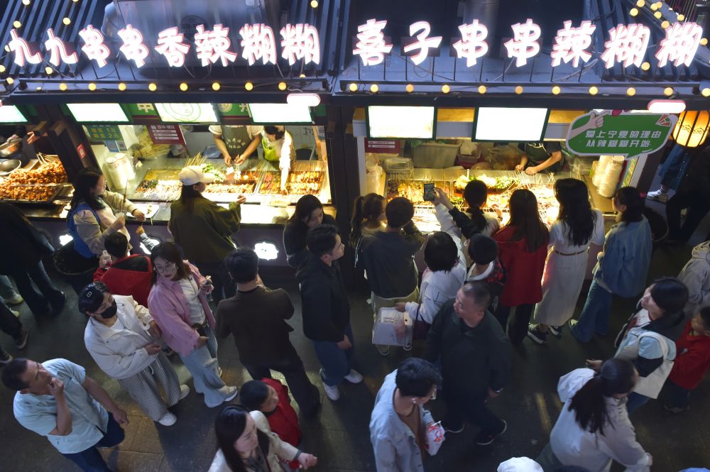 2024年5月4日，游客在寧夏銀川懷遠夜市品嘗當地網紅美食辣糊糊。新華社記者 毛竹 攝