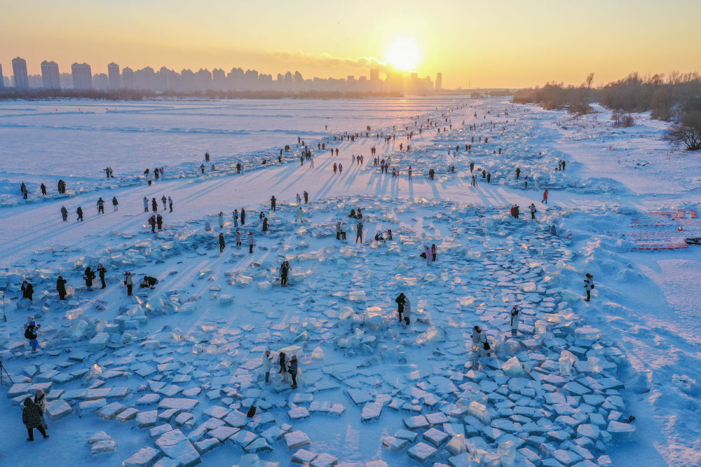 2024年1月7日，在封凍的鬆花江哈爾濱段，游客在日落時分的“鑽石海”游玩（無人機照片）。新華社記者 謝劍飛 攝