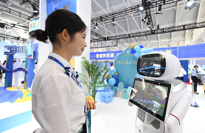 6月20日，與會者在博覽會現場與機器人對話交流。新華社記者 孫凡越 攝