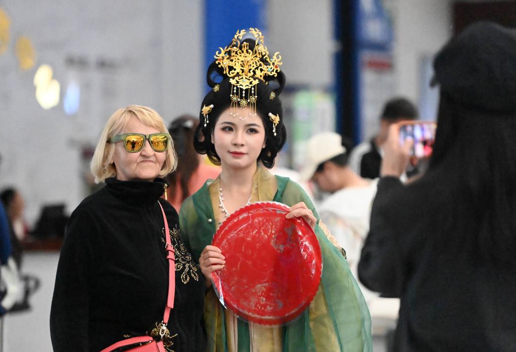 5月1日，一名外籍游客在天津國際郵輪母港客運大廳與演出人員合影。新華社記者 趙子碩 攝