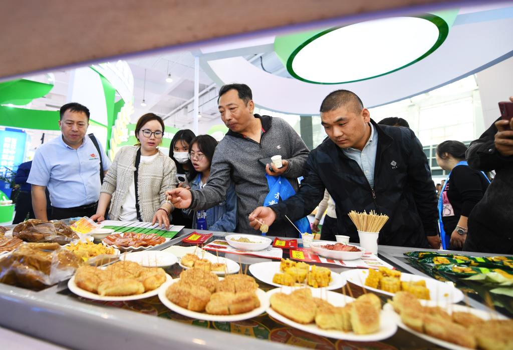 2023年4月10日，参观者在中原农谷预制菜国际博览会上品尝加工好的预制食品。新华社记者 张浩然 摄